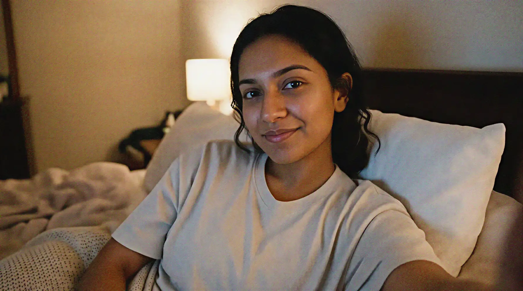 A woman holding her phone for a video call at home in the evening